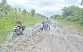  ??  ?? Pobladores utilizan motociclet­as para circular por algunos tramos menos inundados.