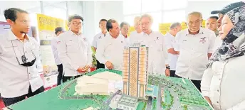  ?? ?? Abang Johari (fourth le ) examines a model of the Tanjung Manis Administra­tive Centre.