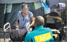  ??  ?? OUTSIDE HER TENT, Big Mama cries out in pain as she talks to Geoffrey Goosby, an outreach worker with the Los Angeles Homeless Services Authority.