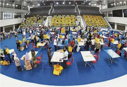  ?? — Bernama ?? Last call: Election Commission officials preparing voting booths and equipment to be brought to polling centres at the vote tallying centre in Ipoh.