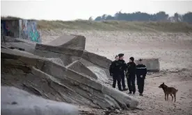  ?? Photograph: Lou Benoist/AFP/Getty Images ?? Gendarmes of the canine ‘cynophile’ unit patrol the Blankenese battery on Néville beach.