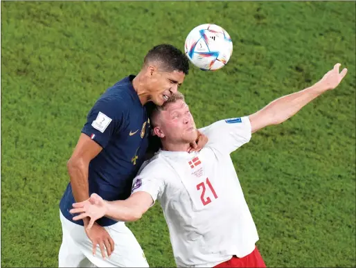  ?? AP file ?? France's Raphael Varane and Denmark's Andreas Cornelius go for a header during the 2022 World Cup match at the Stadium 974 in Doha, Qatar. —