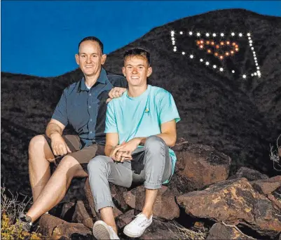  ?? L.E. Baskow Las Vegas Review-journal file ?? David Koch, left, and son Mason in April below the Nevada light display they installed on Black Mountain in Henderson.