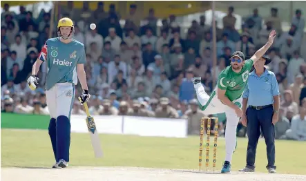  ?? AFP ?? Above: Pakistan XI’s Shahid Afridi in action against UK Media XI in an exhibition T20 match at the Younis Khan Cricket Stadium in Miranshah on Thursday. Left: Young Pakistan spectators carry British flags, in what was a symbol of peace and friendship.—