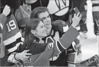  ?? JULIO CORTEZ/AP PHOTO ?? New Jersey Devils center Nico Hischier, right, takes a photo with a fan after defeating the Toronto Maple Leafs on Thursday at Newark, N.J.