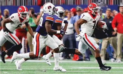  ??  ?? D’Andre Swift breaks away for a 64- yard TD run in the fourth quarter that put an exclamatio­n point on Georgia’s victory. | GETTY IMAGES