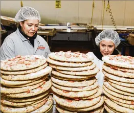  ?? LYNDON FRENCH / THE NEW YORK TIMES ?? Preparing to pack frozen pizza at Home Run Inn Pizza, which has about 135 full-time employees in manufactur­ing, Feb. 22 in Woodridge, Ill. Despite interest rate increases meant to cool the labor market, companies outside the tech industry worry about having too few workers, not too many.