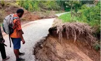  ?? PHOTO FROM MICHAEL DAI VIA AFP ?? ON THE EDGE
This picture received on Tuesday, March 19, 2024, shows a man standing on a road damaged by a landslide in Simbu province, central Papua New Guinea.