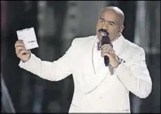  ?? AP PHOTO / JOHN LOCHER, FILE ?? Steve Harvey holds up the card showing the winners after he incorrectl­y announced Miss Colombia Ariadna Gutierrez as the winner at the 2015 Miss Universe pageant in Las Vegas.