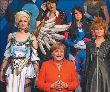  ?? DPA ?? SUPERPODER­OSA. Merkel posa junto a heroínas en un reciente evento de la industria ‘gamer’.