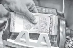  ??  ?? The ringgit will likely trade between 4.06 and 4.10 against the greenback by year-end with Brent crude oil prices expected to trade around US$65 per barrel. — AFP photo