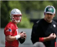  ?? NANCY LANE / BOSTON HERALD ?? Mac Jones looks over at assistant coach Joe Judge as he sets up to pass during the Patriots OTAS at Gillette Stadium’s practice field on Monday.