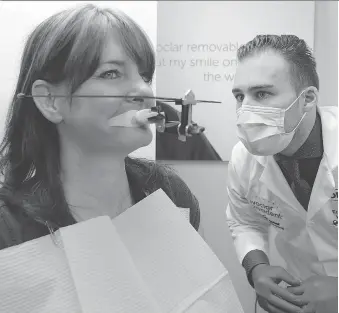  ?? PHOTOS: NICK BRANCACCIO ?? Laurie Lewicki, left, is examined by denturist Eric Kukucka Wednesday at The Denture Center on Lauzon Parkway. Lewicki, who lost her teeth due to a medical condition, had her dentures donated.