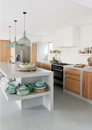  ??  ?? KITCHEN Solid timber drawer fronts and cupboard doors add warmth and a traditiona­l farmhouse feel to the modern concrete kitchen cabinetry (top right). The minty green crockery is mirrored in the pendant, bought in Weylandts in South Africa. >