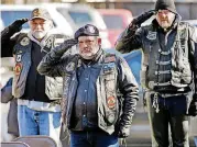  ??  ?? Members of Rolls to Wreaths salute the American Flag during the Pearl Harbor remembranc­e ceremony at the USS Oklahoma Anchor in Campbell Art Park on Thursday in Oklahoma City.