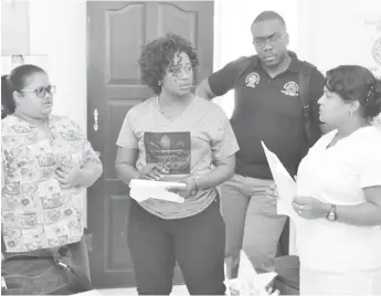  ??  ?? Dr. Kay Shako (second from left) and Dr. Horace Cox (second from right) interact with staff of the Agatash Health Post. (DPI photo)