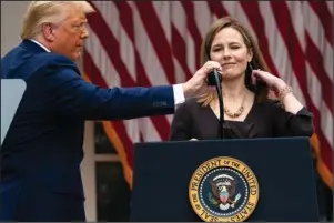  ?? The Associated Press ?? CONFIRMATI­ON HEARINGS: President Donald Trump adjusts the microphone after he announced Judge Amy Coney Barrett as his nominee to the Supreme Court on Sept. 26 in the Rose Garden at the White House in Washington.