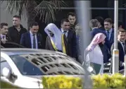  ?? CAN EROK / DHA VIA AP ?? Saudi Arabia’s top prosecutor, Saud al-Mojeb (center left), leaves his hotel to go to his country’s consulate in Istanbul on Tuesday, where journalist Jamal Khashoggi was reportedly killed.