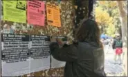  ?? THE ASSOCIATED PRESS ?? In this Sept. 8, 2017, photo, a woman tapes flyers on a University of California, Berkeley campus bulletin board calling for a protest against right-wing speaker Ben Shapiro in Berkeley, Calif.