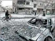  ?? ABDULMONAM EASSA/GETTY-AFP ?? Syrians walk Sunday on a street that shows the effects of shelling in the rebel-held enclave of eastern Ghouta.