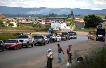  ??  ?? View of cars in line and the Venezuelan Immigratio­n Point (on the background) from the border city of Pacaraima, Roraima, Brazil. — AFP photos