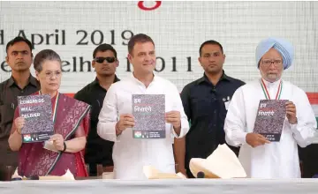  ?? — Reuters photo ?? Gandhi (centre), president of Congress party, his mother and leader of the party Sonia and India’s former Prime Minister Manmohan Singh (right) display copies of their party’s election manifesto for the April/May general election in New Delhi, India.