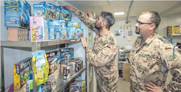  ?? FOTO: BUNDESWEHR IM IRAK ?? Wolle und Eik: Die beiden Kaufleute in Uniform führen den Marketende­r-Laden im deutschen Camp Stephan. In diesen Tagen vor Weihnachte­n sind Playmobil-Figuren gefragt, die die Soldaten nach Hause schicken.