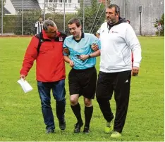  ?? Foto: Otmar Selder ?? Firnhabera­us Abteilungs­leiter Robert Spörel und sein Friedberge­r Kollege Marcus Mendel führen den nach einem Kopftreffe­r benommenen Schiedsric­hter Benedikt Müller vom Platz.