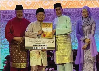  ?? ?? Ahmad Mukhlis accepts his prizes from Wan Junaidi, as Awang Tengah and Fauziah look on.