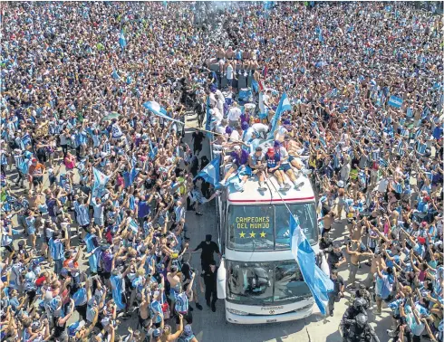  ?? AFP ?? Argentines greet their national team players on an open-top bus during a World Cup victory parade in Buenos Aires on Tuesday.