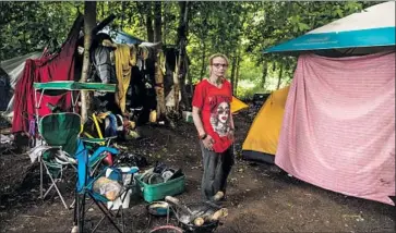  ?? Photograph­s by Ash Adams For The Times ?? CHRISTIANN PERRY, one of Anchorage’s estimated 1,100 homeless, lives in this camp off a public trail. The city gives people 10 days’ notice before clearing out their campsites one by one, but that’s about to change.