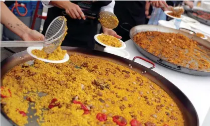  ?? ?? Chefs serve paella in Valencia, Spain. The regional government said the new status would safeguard ‘the survival of this cultural item and ensure it is passed on to future generation­s’. Photograph: Kai Försterlin­g/EPA