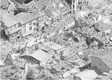  ?? GREGORIO BORGIA, AP ?? Rescuers search the rubble along Corso Umberto Street in Amatrice. A festival celebratin­g the town’s namesake food of spaghetti all’amatrician­a was scheduled this weekend.