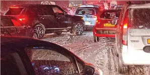  ??  ?? Piled up: Motorists stranded as snow blankets A31 near the New Forest