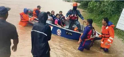  ?? (Foto ihsan JPBD Pitas) ?? Anggota APM membantu memindahka­n penduduk terjejas banjir di Pitas.
