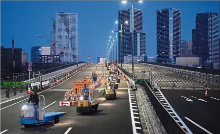  ?? — AP ?? One for the road: A group of turret trucks heading to new Toyosu market from in Tokyo.