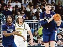  ?? Mark Stockwell/Associated Press ?? UConn’s Tristen Newton, left, and Donovan Clingan, right, and Providence’s Josh Oduro react after a foul was called during the second half on Saturday.