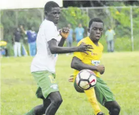  ??  ?? Khamali Burley (right) of Petersfiel­d High has his passage blocked by Knockalva Technical’s Chad Johnson in their ISSA/WATA Zone D firstround game played in Ramble, Hanover, on Thursday. Johnson scored the equaliser for Knockalva Technical as the game ended in a 1-1 draw.