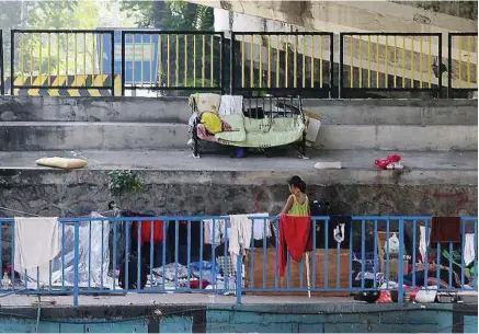  ??  ?? in the open: A girl putting out her laundry to dry under the bridge over the Klang River.