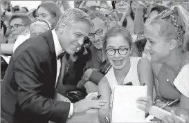  ?? Domenico Stinellis /
The Associated Press ?? George Clooney signs autographs upon his arrival at the premiere of the film “Suburbicon” during the 74th edition of the Venice Film Festival in Venice, Italy.