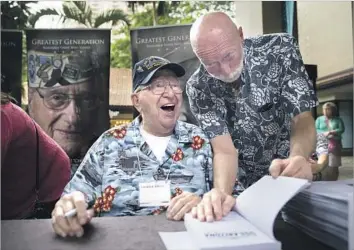  ?? Kent Nishimura For The Times ?? LAUREN BRUNER, seated, with Ed McGrath, signs copies of “Second to the Last to Leave USS Arizona” in Honolulu. “I told Ed for the book so I wouldn’t have to talk about it again,” Bruner says of his memories.