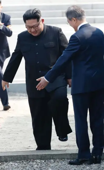  ?? ONE SMALL STEP: South Korea's President Moon Jae- in ( right) gestures to North Korea's leader Kim Jong- un to step over the Military Demarcatio­n Line that divides their countries. Picture: AFP ??