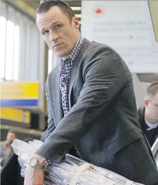  ?? GAVIN YOUNG ?? New Ottawa Senator Dion Phaneuf wraps his sticks Tuesday as he checks in at the Calgary Internatio­nal Airport en route to Detroit, where he’s expected to make his debut with the Sens against the Red Wings.