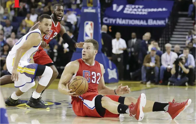  ??  ?? OAKLAND: Los Angeles Clippers’ Blake Griffin (32) looks to pass away from Golden State Warriors’ Stephen Curry, left, during the first half of a pre-season NBA basketball game, Tuesday, in Oakland, Calif. — AP