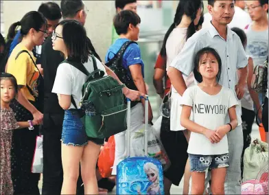  ?? JIN ZHENQIANG / FOR CHINA DAILY ?? A girl tries not to cry at Hankou Railway Station in Wuhan, Hubei province, as she prepares to return home on Sunday. As summer vacation comes to an end, many children of migrant workers who traveled to big cities to spend time with their parents must...