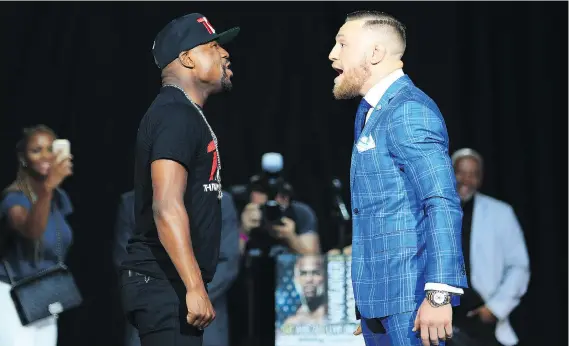  ?? VAUGHN RIDLEY/GETTY IMAGES ?? Floyd Mayweather Jr., left, and Conor McGregor face off for the second straight day during their promotiona­l tour stop in Toronto on Wednesday.