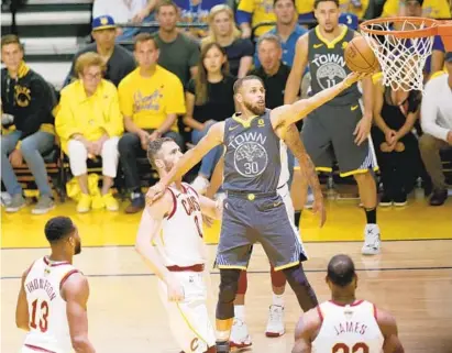  ?? JANE TYSKA/TNS ?? The Warriors’ Stephen Curry makes a layup during the first quarter. Curry shot 11-for-26 from the field as Golden State made 57.3 percent of its shots and three players eclipsed 20 points. The Warriors are two wins away from a second straight title.