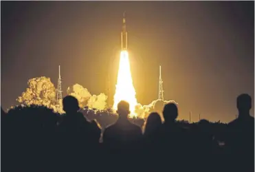  ?? ?? ↑ Spectators watch as the Artemis I rocket lifts off at Nasa’s Kennedy Space Centre