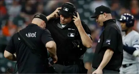  ?? AP Photo/Carlos Osorio ?? This 2019 photo shows home plate umpire Paul Emmel and umpire Mike Estabrook reviewing a play during a baseball game between the Detroit Tigers and the Tampa Bay Rays in Detroit.