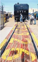  ??  ?? Richard Bugge crosses the tracks behind Santa Fe 2926 during a recent party held to mark the building of an engine house for the locomotive.